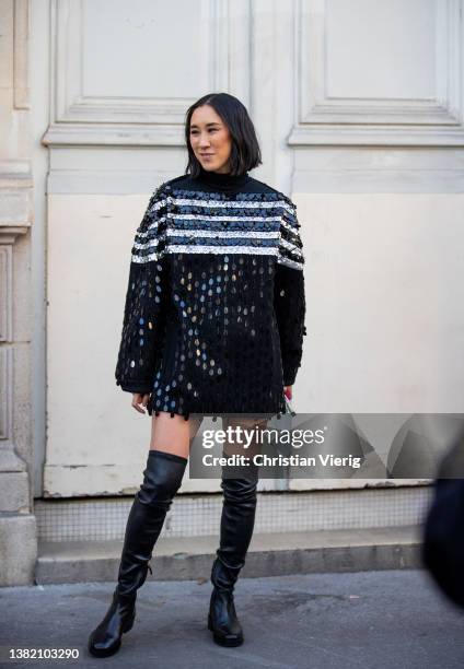 Eva Chen seen wearing black striped glitter oversized jumper, over knees boots outside Valentino during Paris Fashion Week - Womenswear F/W 2022-2023...