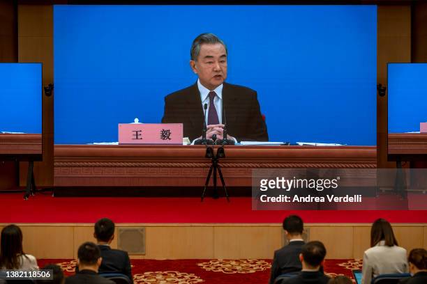 Chinese Foreign Minister Wang Yi is seen on large screens as he holds a press conference at the Media Center on March 07, 2022 in Beijing, China.