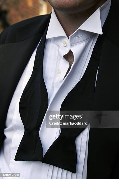 man with untied black bowtie and unbuttoned white shirt - untied stock pictures, royalty-free photos & images