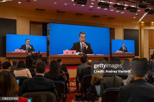 Chinese Foreign Minister Wang Yi is seen on screens as he holds a press conference at the Media Center on March 07, 2022 in Beijing, China.