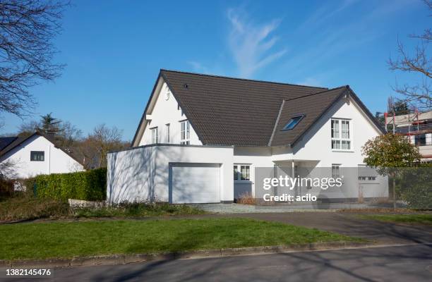 klassisches weißes einfamilienhaus mit garage - einfamilienhaus stock-fotos und bilder