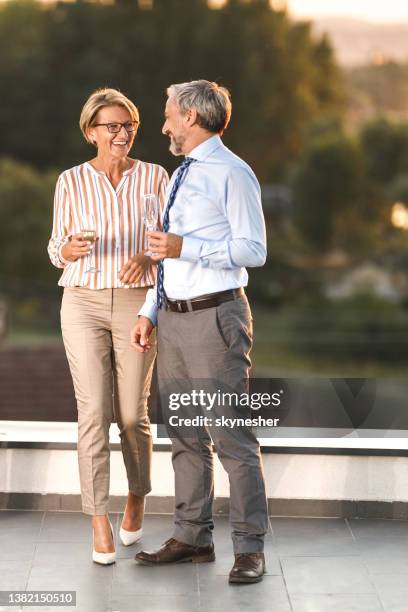 happy business colleagues talking on a rooftop. - champagne rooftop stock pictures, royalty-free photos & images