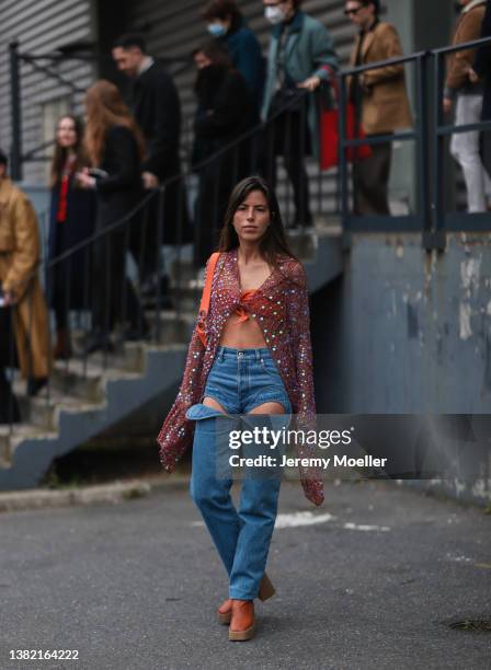 Nina Urgell Cloquell seen wearing a brown mesh knot v-neck cardigan with long sleeves, an orange knot off-shoulder top, an orange shiny leather bag...