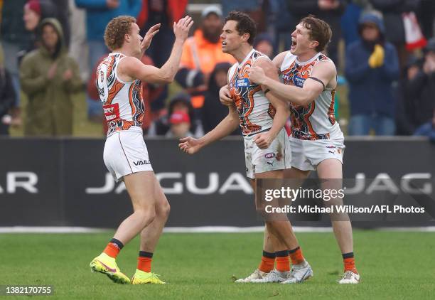 Ryan Angwin, Josh Kelly and Tom Green of the Giants celebrate during the 2023 AFL Round 16 match between the Melbourne Demons and the GWS Giants at...