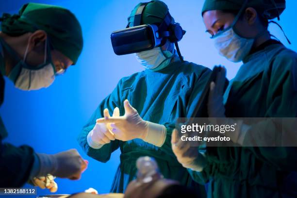 doctors are surgery to patient at operating room. using virtual reality glasses. - virtual care stock pictures, royalty-free photos & images