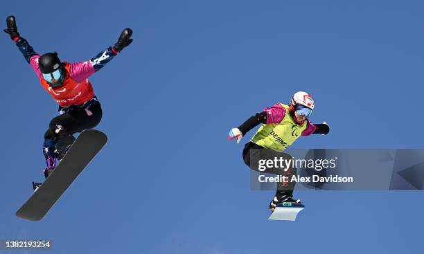 Nianjia Hu of Team China and Brenna Huckaby of Team United States compete in the Women's Snowboard Cross SB-LL2 at Genting Snow Park during day three...