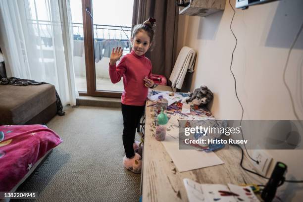 Ukrainian refugee child, Nikol, waves as she plays at a hotel appartment where she is accommodated with their family on March 5, 2022 in Obzor,...