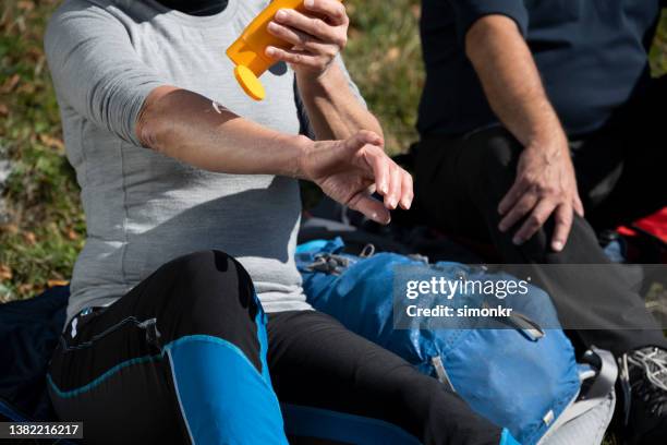 hikers sitting on grassy hill - applying stockfoto's en -beelden