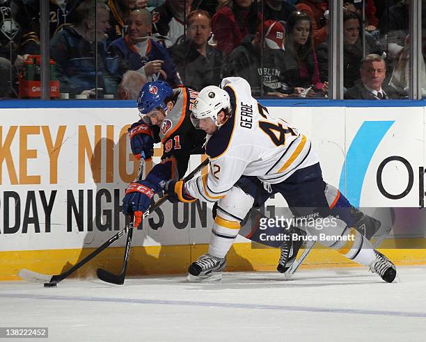 Nathan Gerbe of the Buffalo Sabres and John Tavares of the New York Islanders battle for the puck along the boards at the Nassau Veterans Memorial...