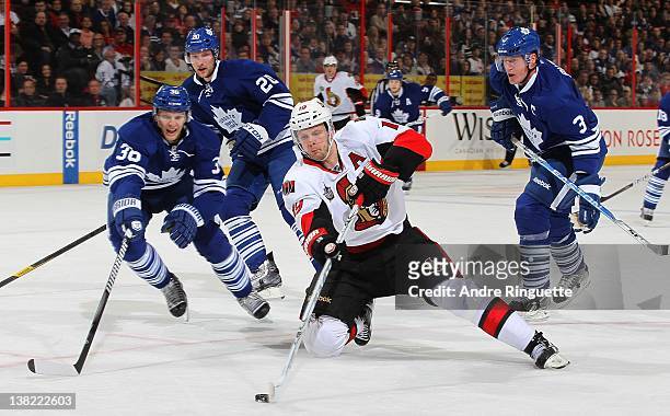 Jason Spezza of the Ottawa Senators takes a backhand shot from his knees against Carl Gunnarsson, David Steckel and Dion Phaneuf of the Toronto Maple...