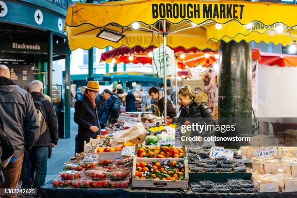 food market employees working on stall at borough market, london, uk - borough market stock pictures, royalty-free photos & images