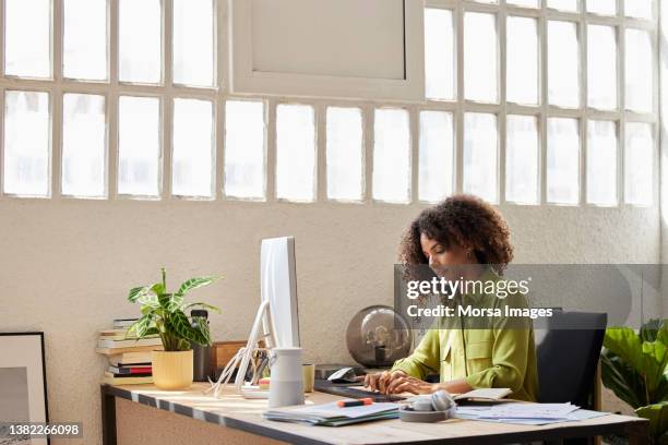 female professional typing while sitting at desk - woman on computer stock pictures, royalty-free photos & images