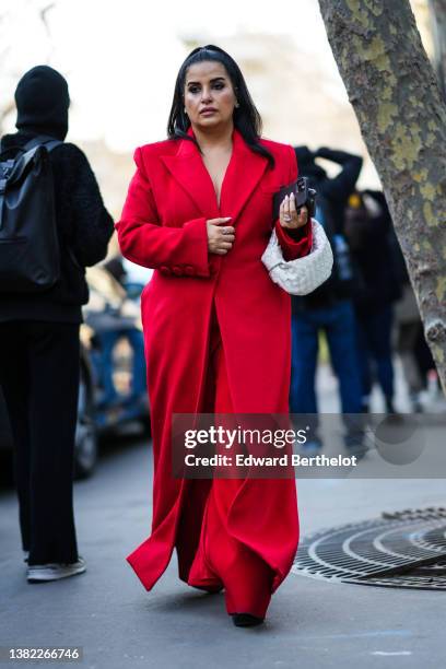 Guest wears a red long coat, red large pants, a white leather braided Jodie handbag from Bottega Veneta, black platform pumps heels shoes, silver...