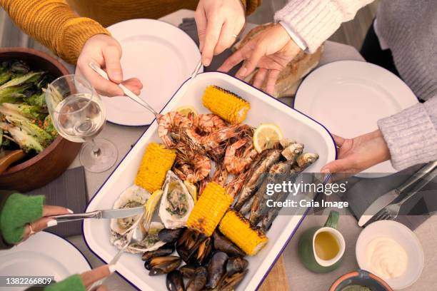 view from above friends enjoying fresh seafood - eating seafood stock pictures, royalty-free photos & images