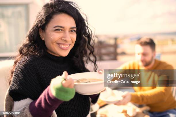 portrait happy woman eating on sunny patio - eating soup stock pictures, royalty-free photos & images