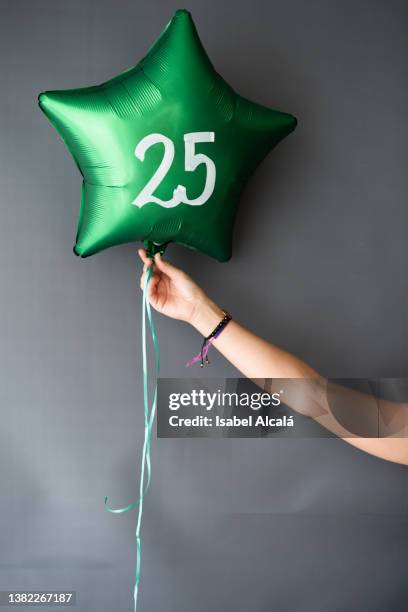 young female hand holding a 25 birthday globe - number 31 個照片及圖片檔