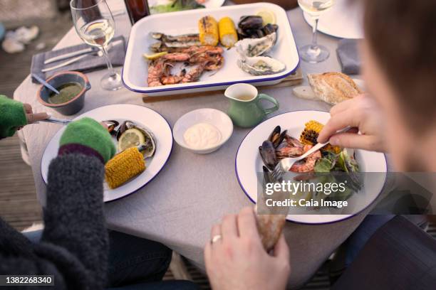 couple enjoying fresh seafood on patio table - couple having dinner stock pictures, royalty-free photos & images