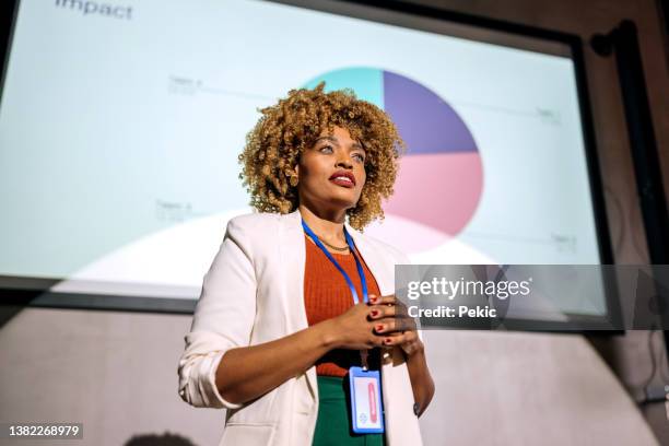 casually clothed hipster woman holding a speech on a conference - presenter stockfoto's en -beelden