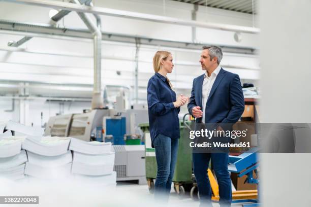 blond businesswoman discussing ideas with colleague in industry - 40 44 years blond hair mature man factory stock pictures, royalty-free photos & images