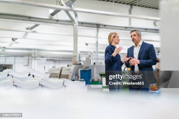 businessman and businesswoman discussing ideas in factory - 40 44 years blond hair mature man factory stock pictures, royalty-free photos & images