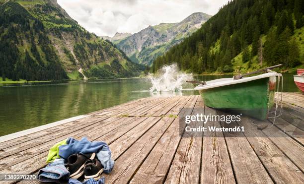 boy jumping into vilsalpsee lake from jetty - bergsteiger stockfoto's en -beelden