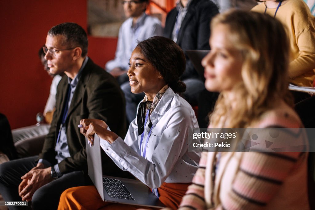 Young beautiful woman attending business conference