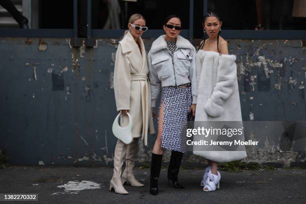 Leonie Hanne seen wearing silver rhinestones Balenciaga earrings, a white latte oversized belted coat, a white Melted Swipe handbag from Coperni,...