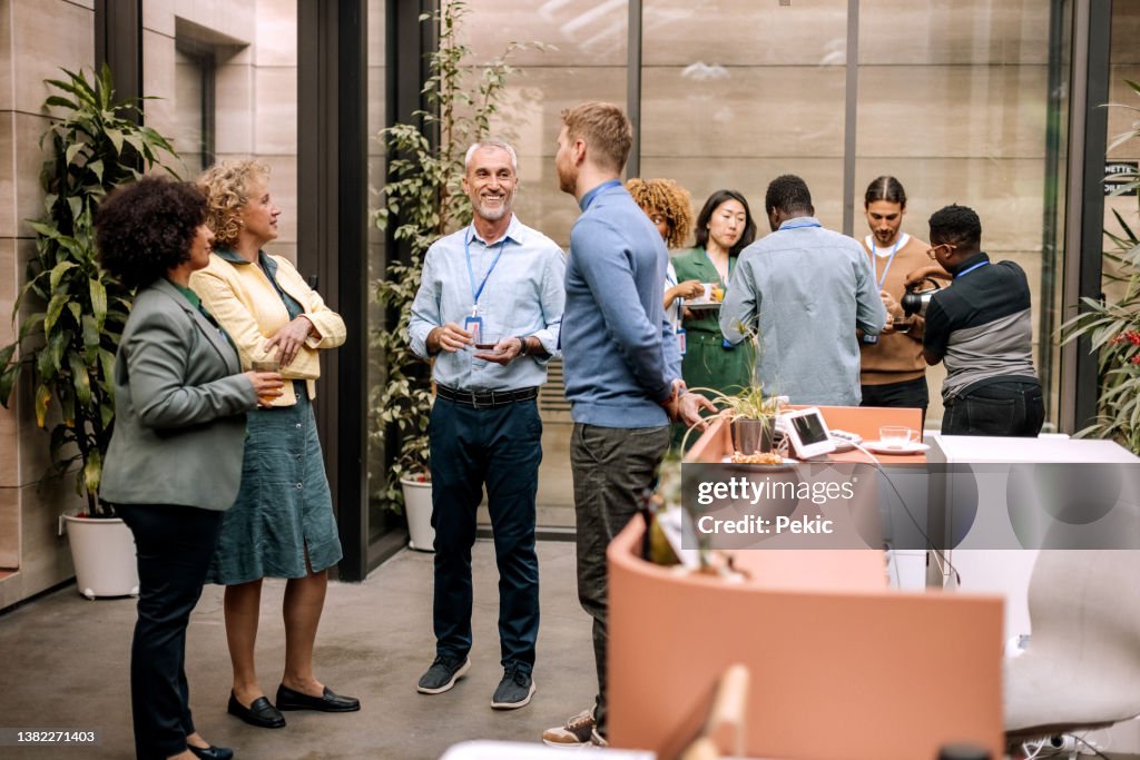 Group of business people having casual conversation while on a refreshment break