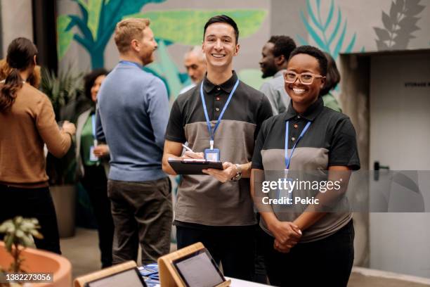 receptionist staff posing for a shot at conference event - employee badge stock pictures, royalty-free photos & images