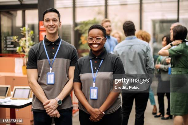 receptionist staff posing for a shot at conference event - employee badge stock pictures, royalty-free photos & images