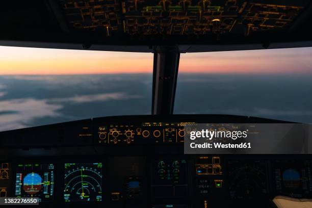 idyllic sunset seen through illuminated cockpit - cabina di pilotaggio foto e immagini stock