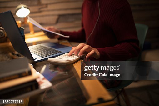 спокойный человек за столом оплачивает счета через ноутбук