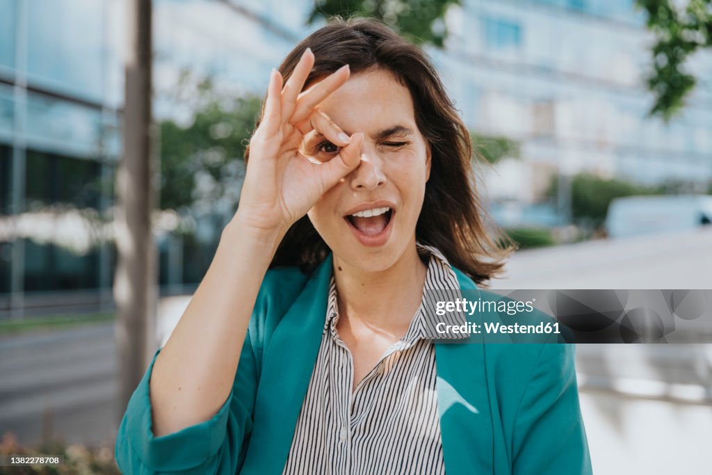 Happy businesswoman in smart casuals making ok gesture sign with hand