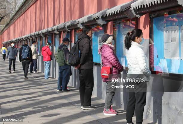 Citizens read reports about 'two sessions' and Beijing 2022 Winter Paralympics at a newspaper corridor of Beihai Park on March 6, 2022 in Beijing,...