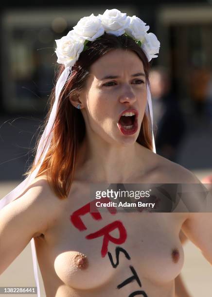 Member of the feminist activist group Femen, with the word "stabbed" written on her body, participates in a demonstration against femicide and...