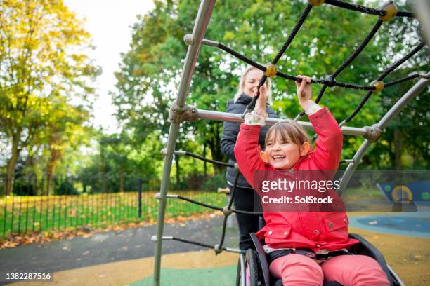 playing in the park with mum - special needs children stock pictures, royalty-free photos & images