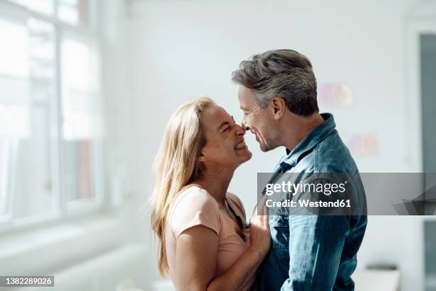 affectionate couple touching noses at home - verliefd worden stockfoto's en -beelden