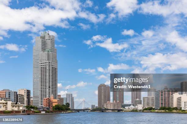 japan, kanto region, tokyo, tsukuda ohashi bridge, saint lukes tower and surrounding skyscrapers - rivière sumida photos et images de collection