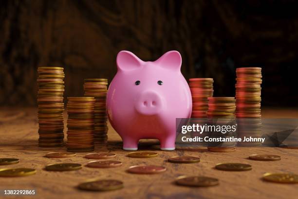 piggy bank and stack of coins - rente stockfoto's en -beelden