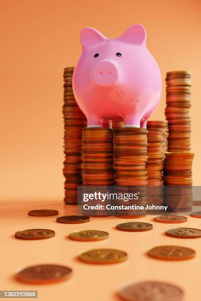 piggy bank standing on top of coins stacks. - zählen stock-fotos und bilder
