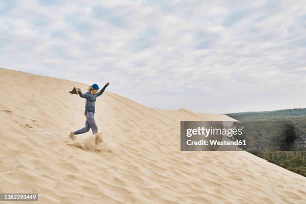 cheerful woman running on sand dune - duna de pilat fotografías e imágenes de stock