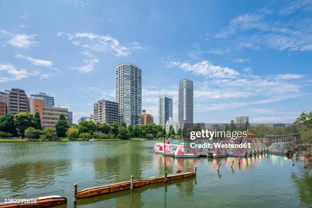 japan, kanto region, tokyo, pedal boats moored on shore of shinobazu pond in summer - ueno park stock-fotos und bilder
