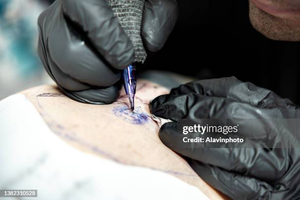 tattoo artist tattooing vitruvian man face - vitruvian man stock pictures, royalty-free photos & images
