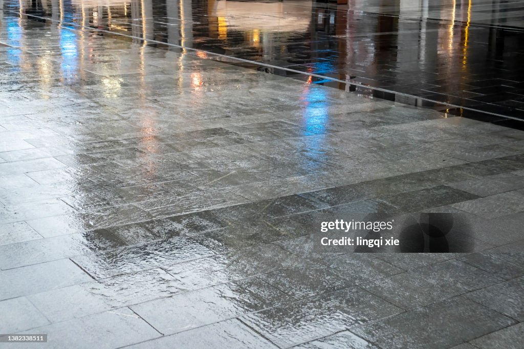 The water-filled square reflects the lights of the city