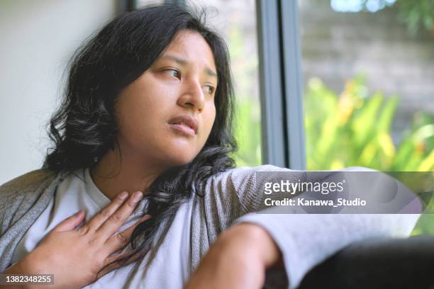 hispanic woman suffering sore throat at home. - agony in the garden stockfoto's en -beelden