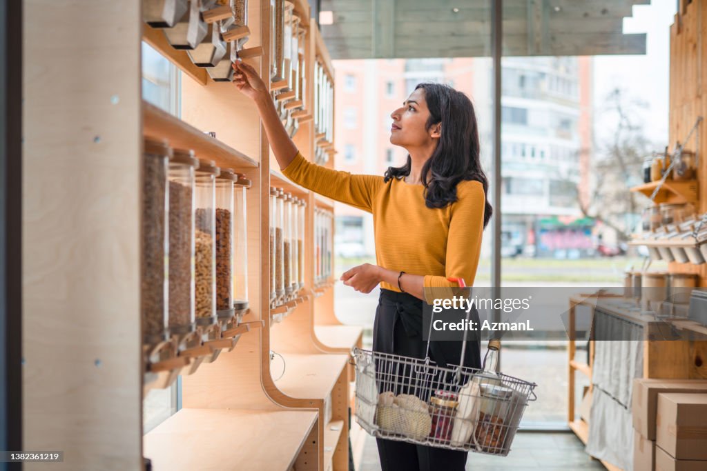 Young Adult Indian Female Shopping In A Sustainable Store