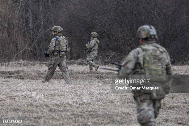 Army soldiers assigned to the 82nd Airborne carry military equipment as they take part in a exercise outside the operating base at the Arlamow...