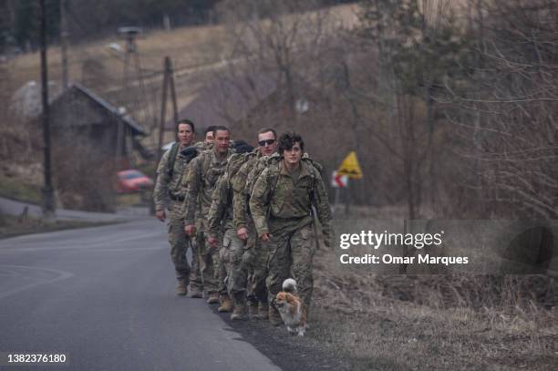 Army soldiers assigned to the 82nd Airborne walk by a village together with a local dog as they head back to the Arlamow Airport on , 2022 in Wola...