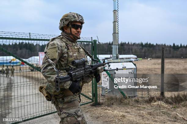 Army soldiers assigned to the 82nd Airborne carry military equipment as they take part in a exercise outside the operating base at the Arlamow...