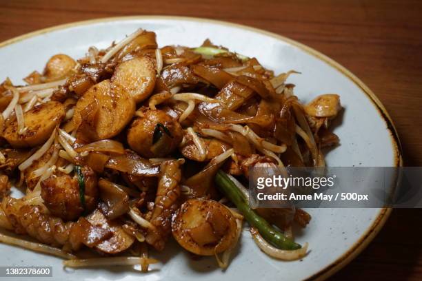char kway teow,close-up of food in plate on table - char kway teow stock pictures, royalty-free photos & images